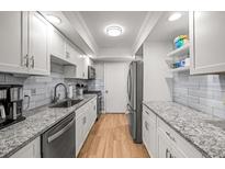 Well-lit kitchen with granite countertops, stainless steel appliances, and wooden floors at 6851 Roswell Rd # I18, Sandy Springs, GA 30328