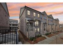 Charming brick townhome showcasing a lovely front porch and professional landscaping at 4145 Essex Pond Way, Cumming, GA 30040