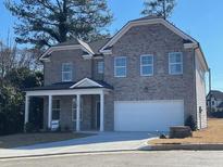 Two-story brick home with a large front porch and three-car garage at 3064 Steinbeck Way, East Point, GA 30344