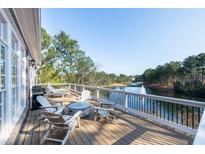 A luxurious deck features outdoor seating and a picturesque view of the lake and fountain, blending relaxation and natural beauty at 6191 Talmadge Run, Acworth, GA 30101