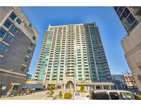 High-rise condo with green glass exterior, multiple balconies, and street-level parking at 361 17Th Nw St # 2208, Atlanta, GA 30363