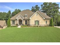 Charming brick home with a stone archway, lush lawn, and mature trees at 1560 Tapestry Rdg, Lawrenceville, GA 30045