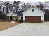 Charming one-story home with white siding, stone accents, and a spacious concrete driveway at 37 Harmony Ridge Dr, Temple, GA 30179