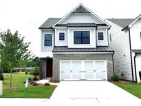 Charming two-story home showcasing a brick and siding exterior, attached two car garage, and well manicured lawn at 1059 Crest Mill Dr, Marietta, GA 30008