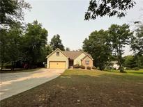 Charming single-Gathering home with a well-manicured lawn, stone accents, and an attached garage, surrounded by mature trees at 75 Briar Patch Rd, Covington, GA 30014