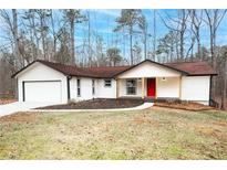 Charming single-story home with a bright red front door and attached two car garage at 6881 Hickory Hollow Dr, Douglasville, GA 30135