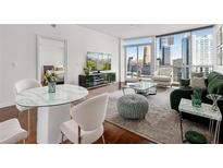 Bright living room with hardwood floors, city views, and comfortable modern furniture at 3325 Piedmont Ne Rd # 1708, Atlanta, GA 30305