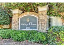 Gated community entrance with stone signage and landscaping at 2400 Cumberland Se Pkwy # 322, Atlanta, GA 30339