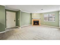 Spacious living room features neutral carpet, fresh paint, and a cozy fireplace at 511 Barrington Hills Dr, Atlanta, GA 30350