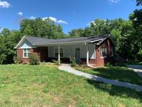Charming bungalow with brick accents and a walkway leading to the front door, nestled in a lush, green yard at 2467 Shady Grove Rd, Carrollton, GA 30116