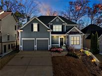 Two-story house with gray siding, three-car garage, and landscaping at 243 Yorkshire Ln, Villa Rica, GA 30180