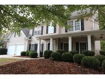Traditional two-story home with a manicured front yard, covered entry, and a two car garage at 6131 Windflower Dr, Powder Springs, GA 30127