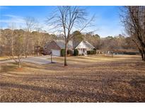 Charming single-Gathering home boasts a large front yard, deck, basketball court, and inviting curb appeal at 289 Barn Rd, Canton, GA 30115
