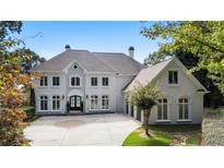 Stunning two-story home with a grand entrance, a circular driveway, and manicured landscaping at 8380 Sentinae Chase Dr, Roswell, GA 30076