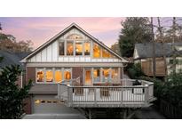 Stunning rear elevation with large deck, floor-to-ceiling windows, and garage access, perfect for entertaining at 833 E Morningside Ne Dr, Atlanta, GA 30324