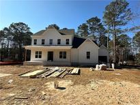 A charming two-story white home with a covered front porch, nestled among tall trees under a clear blue sky at 10350 Alvin Road, Alpharetta, GA 30022