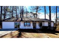 Newly renovated house exterior boasts white siding, dark trim, and a welcoming front porch at 204 Apple Branch Dr, Woodstock, GA 30188