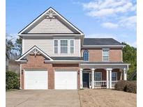 Charming two-story home featuring a brick facade, two-car garage, and covered porch area at 106 Puckett Ct, Canton, GA 30115