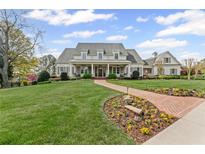 Expansive two-story home features a brick path with lush landscaping and a manicured lawn at 710 Cox Rd, Roswell, GA 30075