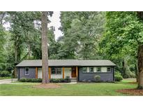 Charming ranch home with brick facade, updated landscaping, and a tree-lined front yard at 131 Brookwood Sw Dr, Marietta, GA 30064