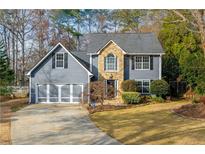 Gray two-story house with stone accents, three-car garage, and landscaped yard at 2410 Emerald Dr, Loganville, GA 30052