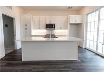 Modern kitchen with white cabinets, large island, and stainless steel appliances at 556 Sawnee Village Blvd # D76, Cumming, GA 30040