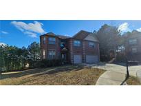 Brick two-story house with three-car garage and landscaped lawn at 870 Belmar Pass, Fairburn, GA 30213