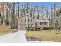 Two-story house with attached garage and deck, nestled in a wooded area at 1531 Harbour Oaks Rd, Tucker, GA 30084