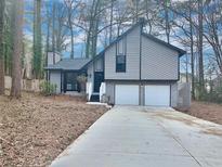 Charming two-story house with a gray exterior, two-car garage, and a long driveway at 3814 Whaley Ct, Snellville, GA 30039