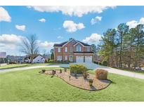 Beautiful two-story brick home with a circular driveway and a well-manicured front yard at 1268 Windsor Glen Dr, Douglasville, GA 30134