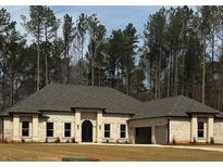 Stunning single-story home with a lush wooded backdrop and a meticulously maintained front yard at 125 Drummond Pl, Covington, GA 30014