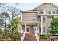 Charming two-story home with a brick stairway leading to the covered front porch at 1409 Oakridge Cir, Decatur, GA 30033