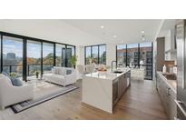 Bright and airy living room with floor-to-ceiling windows and modern kitchen with island at 2425 Peachtree Ne Rd # 510, Atlanta, GA 30305