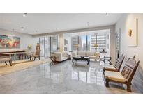 Bright living room featuring marble floors, modern furniture, and large windows with city views at 147 15Th Ne St # 10C, Atlanta, GA 30309