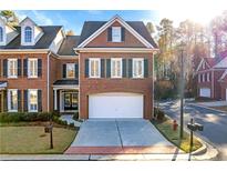 Brick front townhouse with a two-car garage and well-manicured lawn at 108 Magnolia Grv, Alpharetta, GA 30022