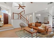 Inviting living room with vaulted ceiling, hardwood floors, modern furniture, and a staircase with white and wood railing at 1827 Rockridge Pl, Atlanta, GA 30324