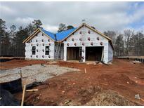 Exterior view of new construction showcasing the home's framing, wrapped with protective material and a blue-covered roof at 1586 Sungrown Way, Mcdonough, GA 30253