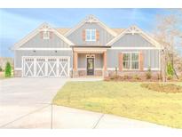 Gray farmhouse exterior with white accents, landscaping, and a two-car garage at 169 Alaina Rd, Holly Springs, GA 30115
