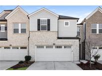 Modern two-story townhome with gray and brick exterior, two-car garage, and landscaping at 1347 Sunny Lake Dr, Lawrenceville, GA 30043