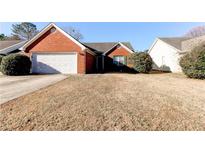 Brick ranch home with attached garage and grassy yard at 1624 Graystone Dr, Hampton, GA 30228