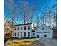 Two-story white house with attached two-car garage and landscaped lawn at 3290 Ethan Dr, Marietta, GA 30062