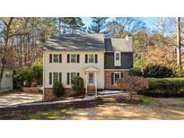 Two-story house with brick and siding, landscaping, and a spacious yard at 9735 Hillside Dr, Roswell, GA 30076