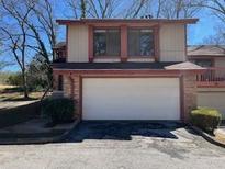 Charming two-story townhome featuring a two-car garage and mature trees at 1153 Village Main St, Stone Mountain, GA 30088