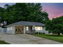 Charming single-story home with white painted brick and a well-maintained front yard at twilight at 1522 Waltham Se Pl, Atlanta, GA 30316