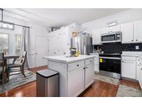 Well-lit kitchen features stainless steel appliances, a center island, and white cabinets and countertops at 2804 Parkway Cv, Lithonia, GA 30058