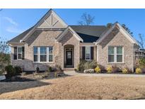 Charming brick home features a manicured lawn, black shutters, and welcoming front door at 514 Perdue Trl, Canton, GA 30115