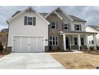 Charming two-story home with a two-car garage, covered porch and stylish mixed material facade at 3355 Hillshire Dr, Cumming, GA 30028