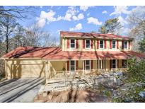 Two-story house with red roof, attached garage, and wrap-around porch at 210 Bluff Creek Dr, Woodstock, GA 30188