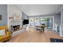 Bright living room featuring a stone fireplace, hardwood floors, and sliding doors to the outside at 3030 Sawtooth Cir, Johns Creek, GA 30022