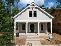Charming cottage-style home with a welcoming front porch and craftsman details, nestled in a serene, wooded neighborhood at 11792 Serenbe Ln, Chattahoochee Hills, GA 30268